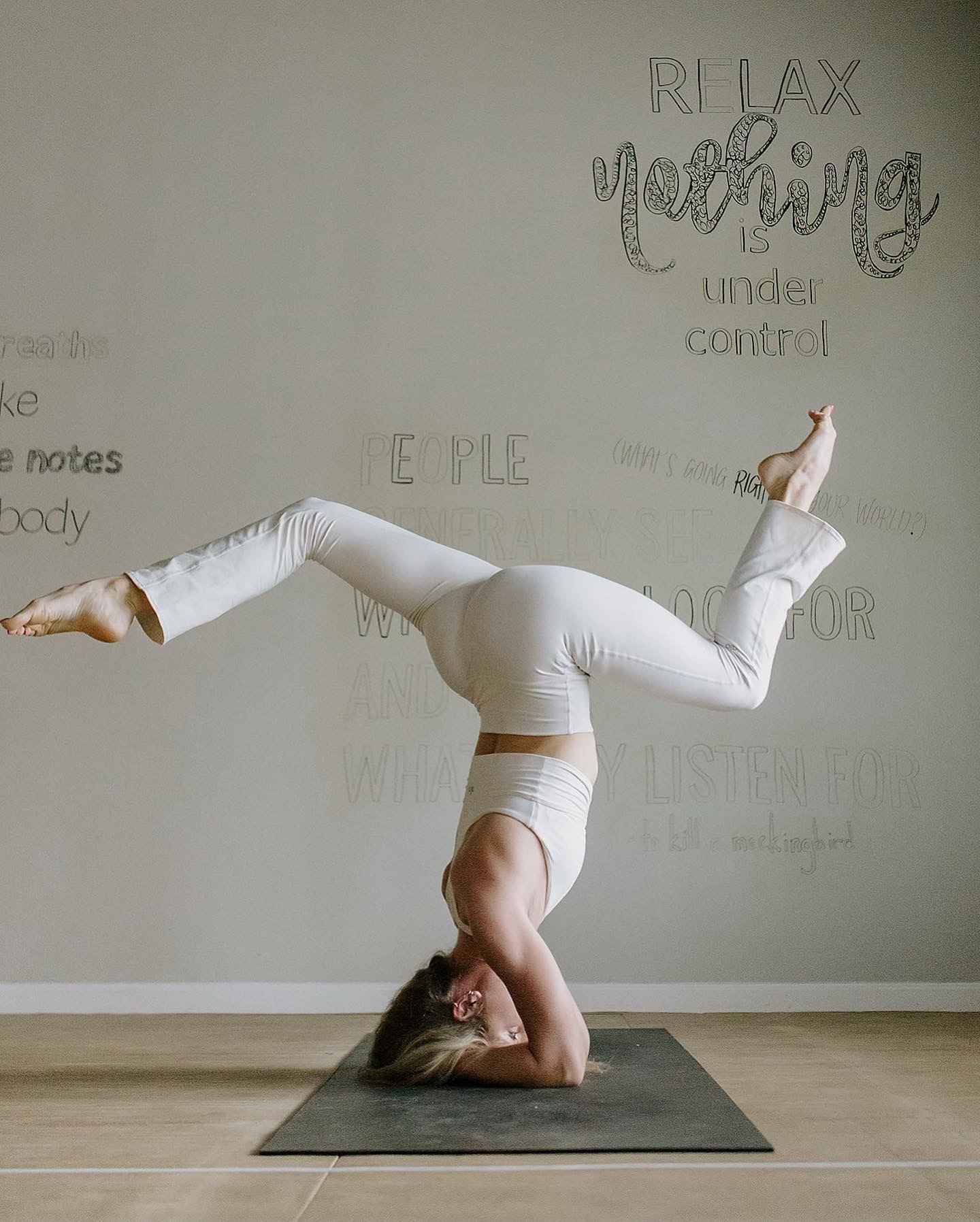 Lily holding a supported headstand variation on a mat